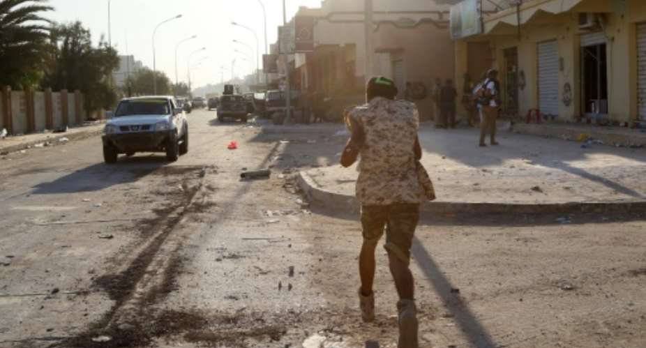 A member of the forces loyal to Libya's UN-backed Government of National Accord runs on a street on August 21, 2016.  By Mahmud Turkia AFPFile