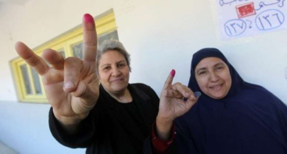 Egyptian women show their ink-stained fingers after voting at a polling station in Cairo's al-Sahel district yesterday.  By Khaled Desouki AFP