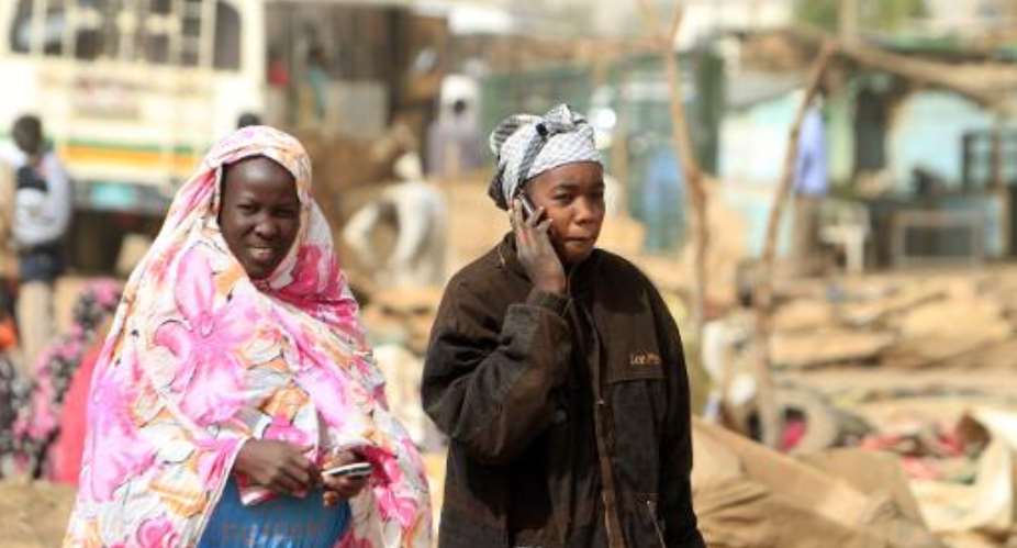 Women use their phones in Khartoum on December 14, 2013.  By Ashraf Shazly AFPFile