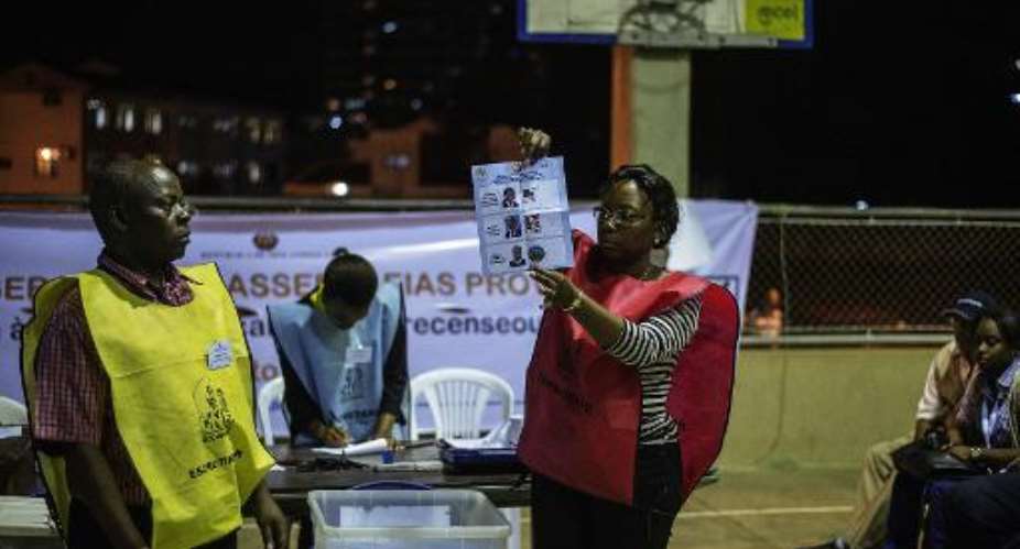 A Mozambican electoral commission voting official at a polling station holds a marked ballot during counting procedures after general elections on October 15, 2014 in Maputo.  By Gianluigi Guercia AFPFile