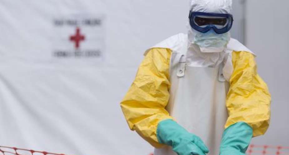 A health worker wearing personal protective equipment works at the Ebola treatment center run in Macenta, Guinea on November 20, 2014.  By Kenzo Tribouillard AFP