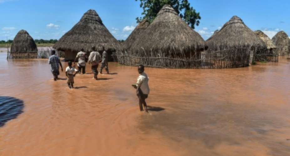Villagers at Onkolde in Kenya's Tana River delta region struggled with flood water after the river burst its banks. More than 60,000 people have displaced from the area, according to the Kenya Red Cross..  By ANDREW KASUKU AFP