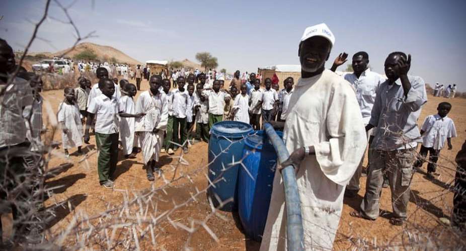 Mn filling barrels with drinking water in el-Srief, North Darfur, on July 25.  By Albert Gonzalez Farran AFPUNAMIDFile