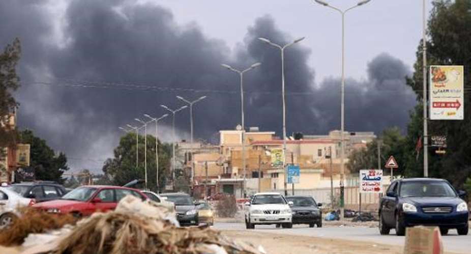 Smoke billows from buildings in Benghazi after being pounded by Libyan air forces loyal to former general Khalifa Haftar, October 22, 2014.  By Abdullah Doma AFP