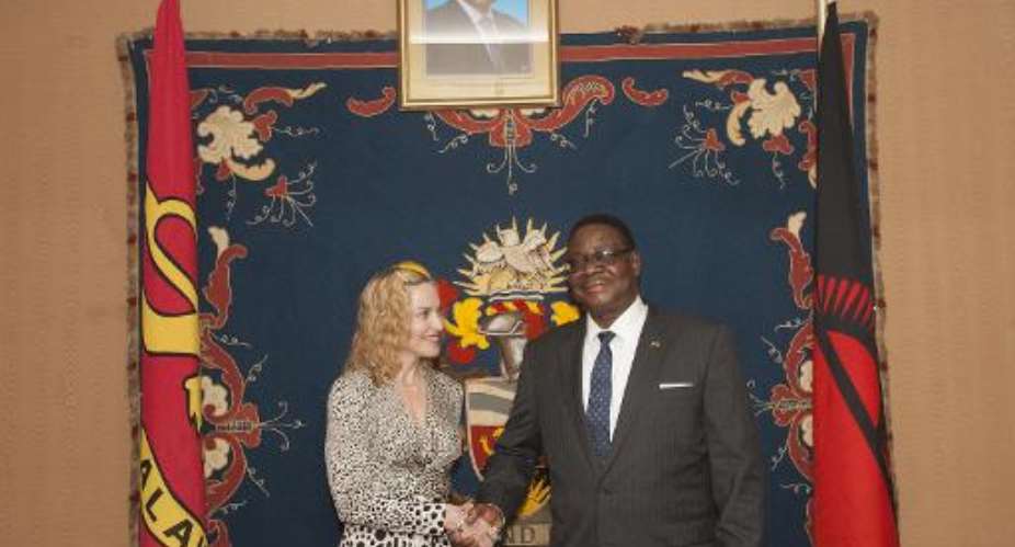 US pop star Madonna shakes hands with Malawi's president Professor Peter Mutharika at Kamuzu Palace in Lilongwe, November 28, 2014.  By Amos Gumulira AFP