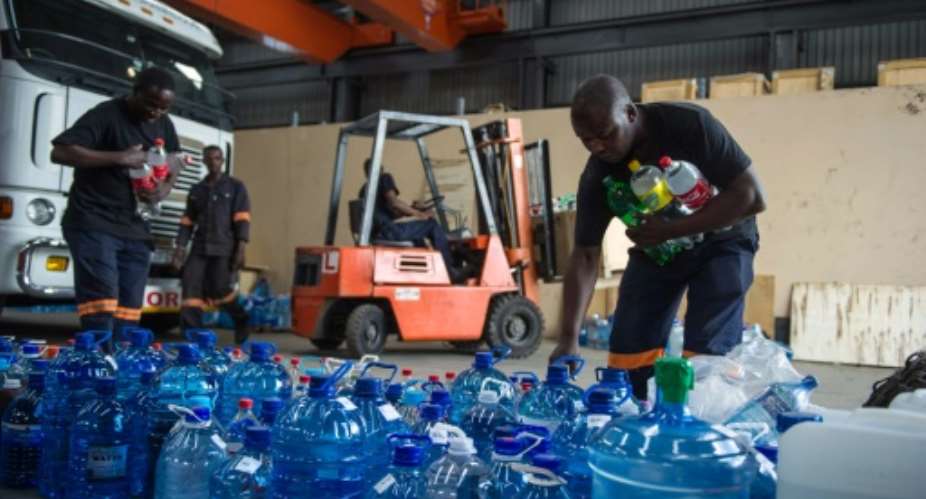 Factory workers in Benoni on the outskirts of Johannesburg, South Africa pile up donated water bottles by residents to be delivered in drought stricken rural communities on January 15, 2016.  By Mujahid Safodien AFPFile