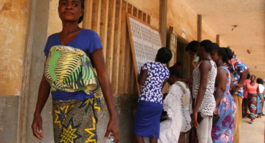 Voters consult an electoral notice in Lome's Be neighbourhood on polling day with 14 opposition groups urging a boycott citing irregularities and demanding constitutional reform.  By MATTEO FRASCHINI KOFFI AFP