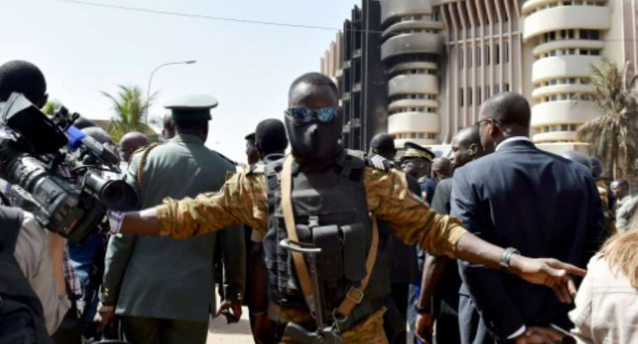 A police officer stands guard during a visit by Burkina Faso's and Benin's presidents to the Splendid hotel and the Capuccino cafe on January 18, 2016 in Ouagadougou.  By Issouf Sanogo AFP
