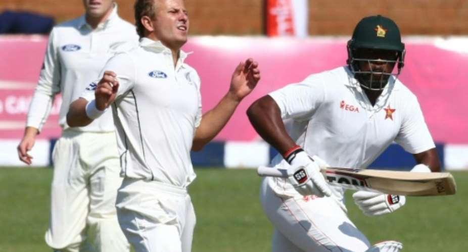 Zimbabwe batsman Hamilton Masakadza R runs past New Zealand bowler Neil Wagner during the first day of the first Test at Queens Sports Club in Bulawayo July 28, 2016.  By Jekesai Njikizana AFPFile