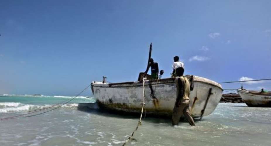 Armed Somali pirates prepare a skiff in Hobyo, northeastern Somalia, in 2010.  By Mohamed Dahir (AFP/File)