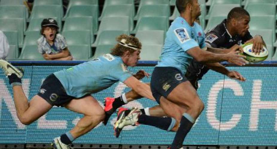 NSW Waratahs' Kurtley Beale C and Michael Hooper attempt to stop the Sharks' Sibusiso Sithole from scoring a try during their Super 15 rugby union match, in Sydney, on May 16, 2015.  By Peter Parks AFPFile