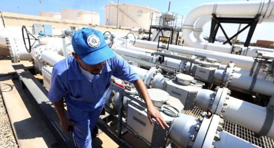 A Libyan oil worker checks oil pipelines at the Zawiya oil installation on August 22, 2013.  By Mahmud Turkia AFPFile