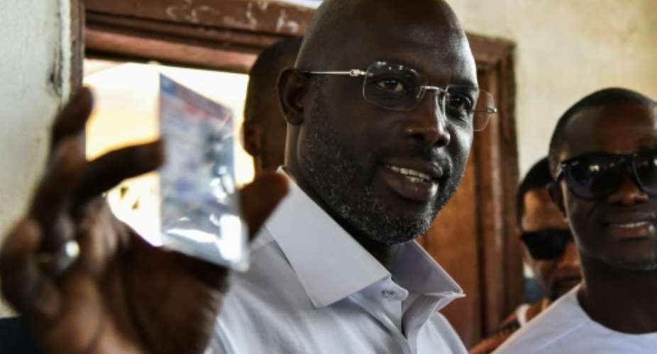 Weah in the running: Former international Liberian football star George Weah will go head-to-head with Joseph Boakai for the Liberian presidency..  By ISSOUF SANOGO (AFP)