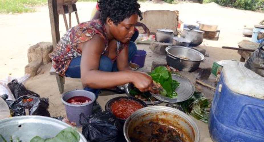 A woman prepares food on April 8, 2014 at a maquis, a small restaurant, in Kobakro, outside Abidjan, which has stopped serving bushmeat since West Africa's Ebola outbreak.  By Issouf Sanogo AFPFile