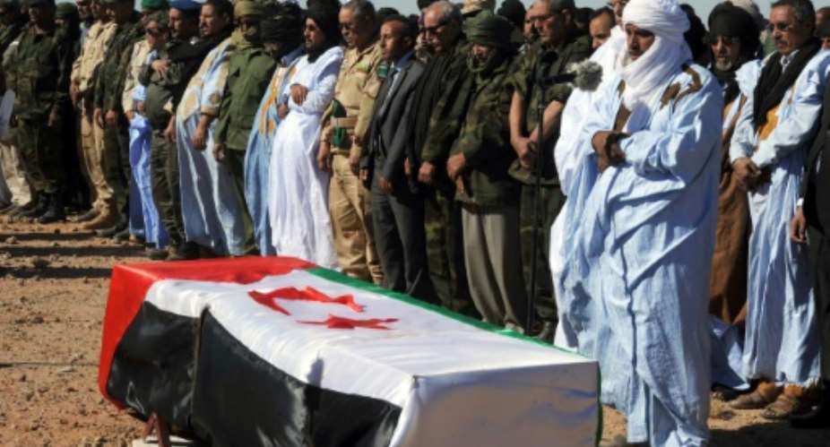 Mourners and members of the Sahrawi People's Liberation Army pray next to the coffin of Polisario Front's secretary general, Mohamed Abdelaziz, during his funeral on June 4, 2016 in the disputed territory of Western Sahara.  By Farouk Batiche AFP