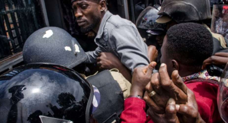 Wine wearing a red beret was dragged out of his car and arrested.  By Badru KATUMBA AFP