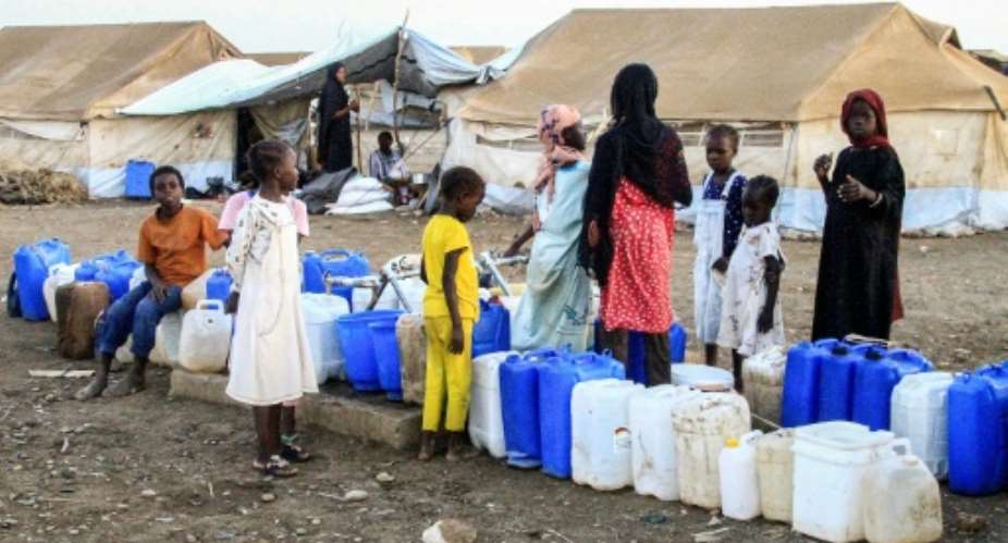 Women and children queue for water at Huri camp for the displaced south of Gedaref in east Sudan, on March 29.  By Ebrahim Hamid AFP