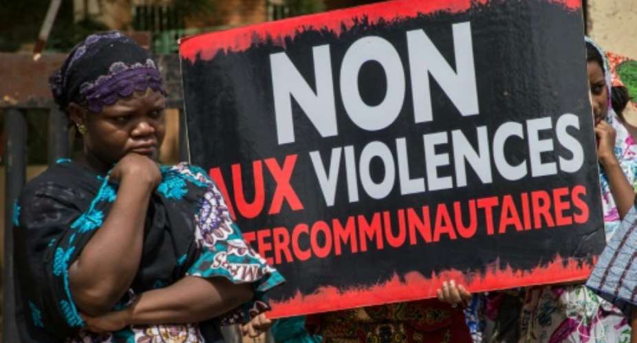 Women hold a sign reading 'No to intercommunity violence' after Fulani villagers in northern Burkina Faso were massacred in 2019 reprisal for a jihadist attack.  By OLYMPIA DE MAISMONT AFP