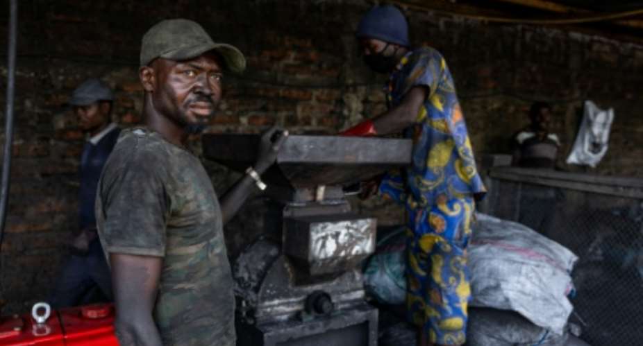 Workers crush burnt agricultural waste at a green coal production plant in Chad.  By Joris Bolomey (AFP)