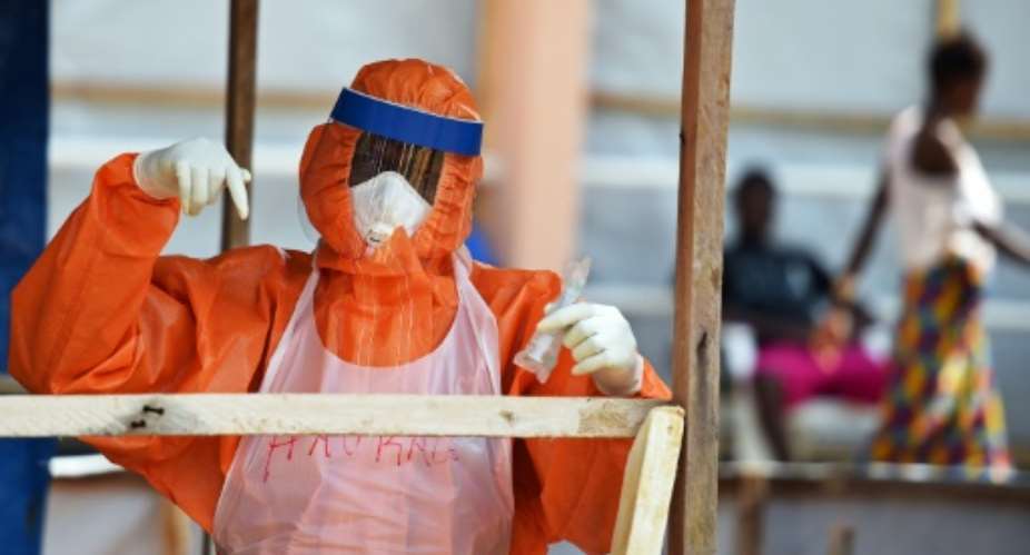 A health worker wearing personal protective equipment works on November 11, 2014 in the red zone of the Hastings treatment center outside Freetown.  By Francisco Leong AFPFile