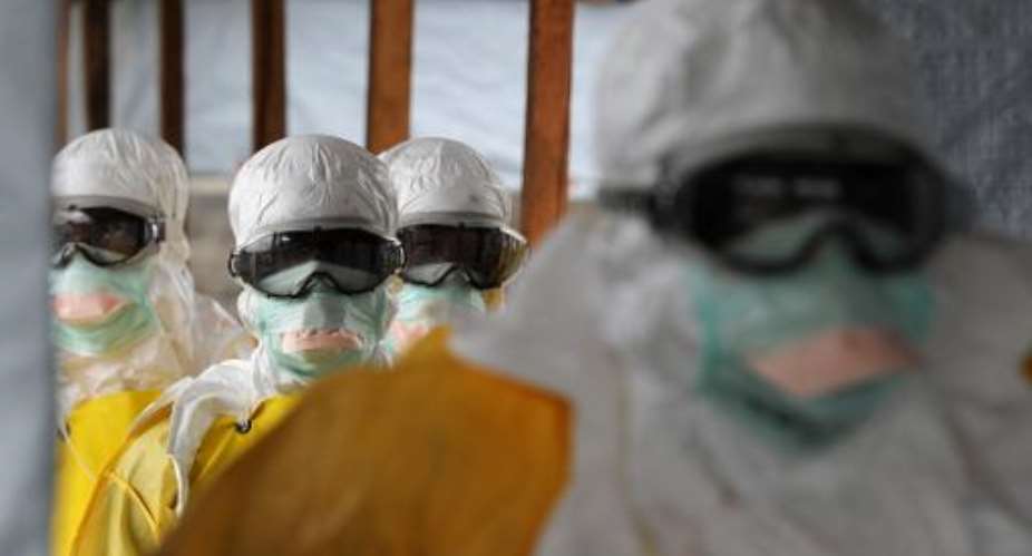 Health care workers, wearing protective suits, leave a high-risk area at the MSF-run Elwa hospital on August 30, 2014 in Monrovia.  By Dominique Faget AFP