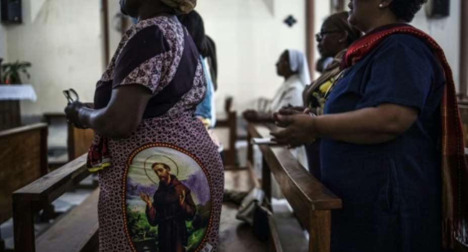 Worshippers pray in Beira's Our Lady of the Rosary Cathedral before Pope Francis visits Mozambique. One woman wears an image of St. Francis of Assisi on her traditional dress.  By MARCO LONGARI AFPFile