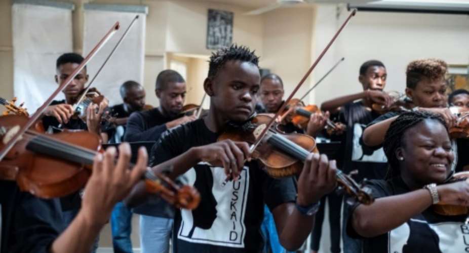Xolani Zingeni centre is one of dozens of youngsters from South Africa to study an instrument at Buskaid, a school specifically for black township children.  By WIKUS DE WET AFP