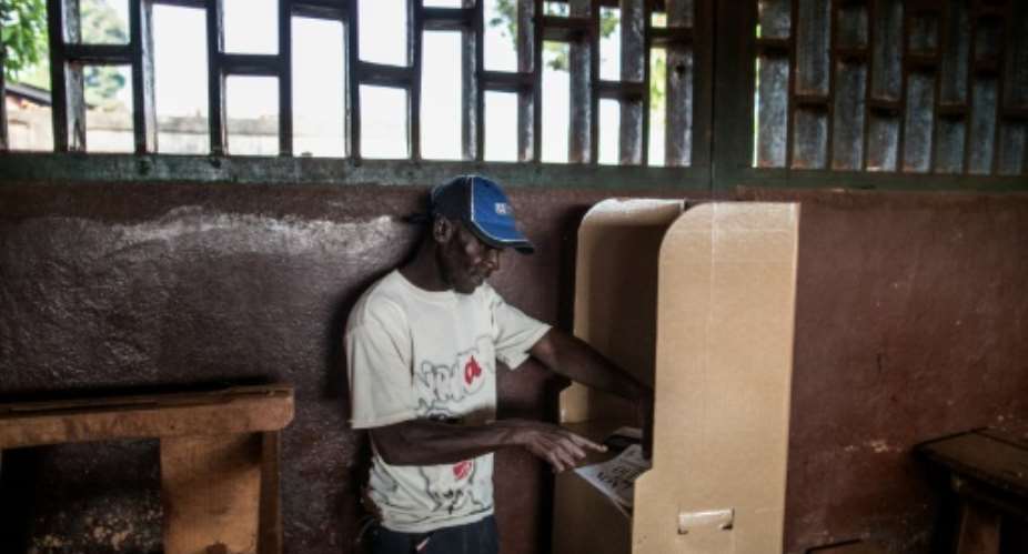 A voter reads his ballot at a polling station in Bangui on December 13, 2015 to vote for the constitutional referendum.  By Marco Longari (AFP/File)