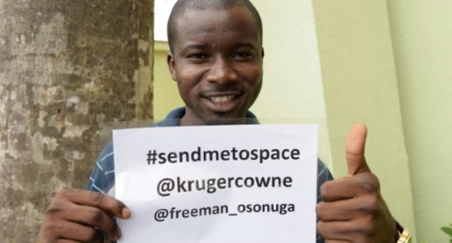 Space enthusiast Freeman Osonuga holds a campaign flyer to solicit support for his quest to be selected to be the first black African in space in Lagos on August 21, 2015.  By Pius Utomi Ekpei AFP