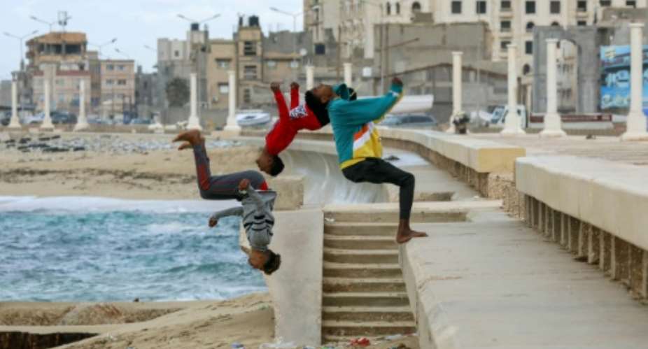 Youths practice parkour stunts along a beach in Libya's eastern second city of Benghazi on December 14, 2021.  By Abdullah DOMA AFP