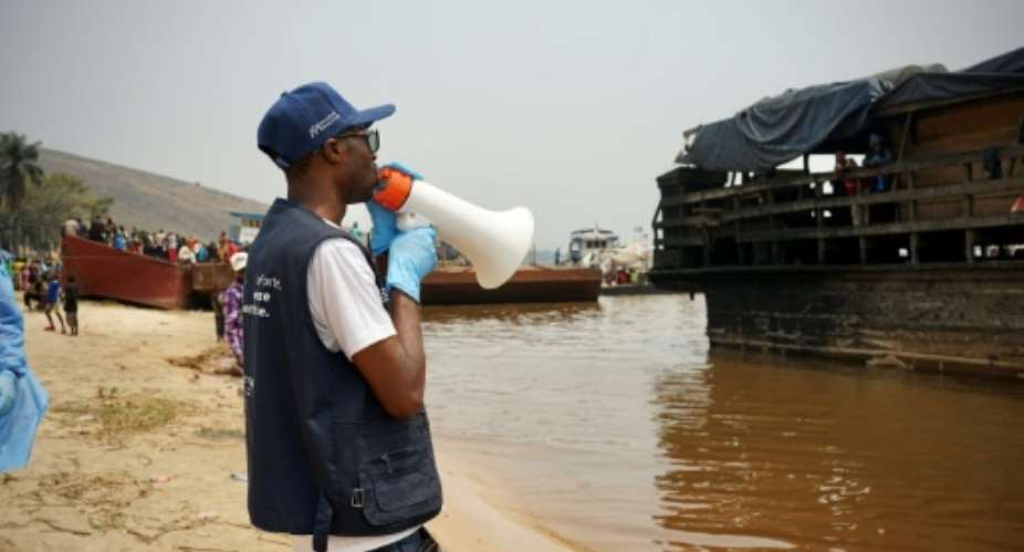 Yves Matwa, an Ebola outbreak response worker, tells passengers on Congo river ferries to brace for checks before they can enter the DR Congo capital Kinshasa.  By Sophie Douce (AFP)
