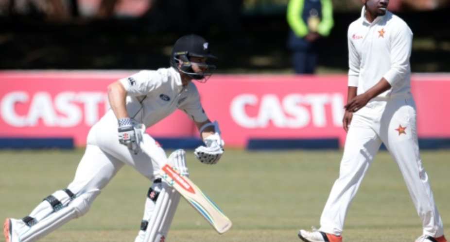 New Zealand batsman Kane Williamson L in action as bowler Chamu Chibhabha looks on during the fourth day of the second Test at the Queens Sports Club in Bulawayo, on August 9, 2016.  By Jekesai Njikizana AFP