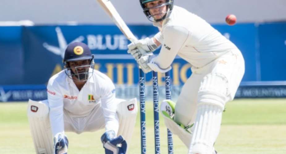 Zimbabwe batsman Peter Moor plays a shot as Sri Lanka wicketkeeper Kusal Janith Perera looks on during the third day's play in the first Test at the Harare Sports Club on October 31, 2016.  By Jekesai Njikizana AFP