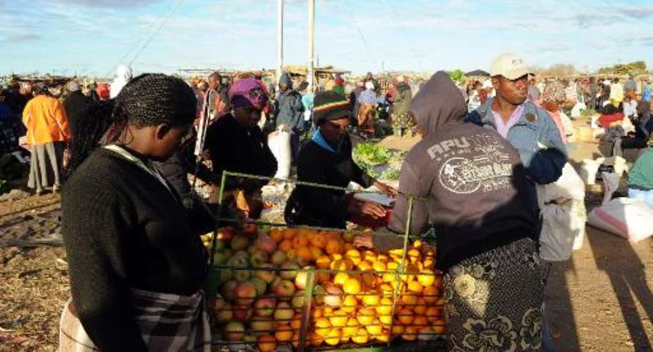 Zimbabwean women shop for vegetables in Jambanja market in Seke, 58km south of Harare.  By Alexander Joe AFPFile