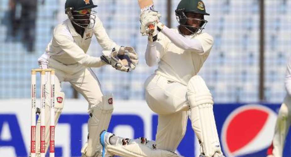 Bangladeshi cricketer Shakib Al Hasan R plays a shot as Zimbabwe wicketkeeper Regis Chakabva looks on during the second day of the third Test in Chittagong on November 13, 2014.  By  AFP