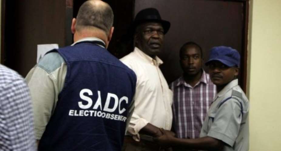 Election observers get accreditation in Harare on March 13, 2013 ahead of Zimbabwe's constitutional referendum.  By Jekesai Njikizana AFP
