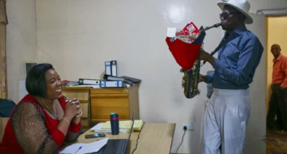 Zimbabwean lawyer Tarisai Leoba was surpised in her workplace by saxophonist Arundel Matoi, who was hired by her husband to deliver a romantic tune.  By Jekesai NJIKIZANA AFP
