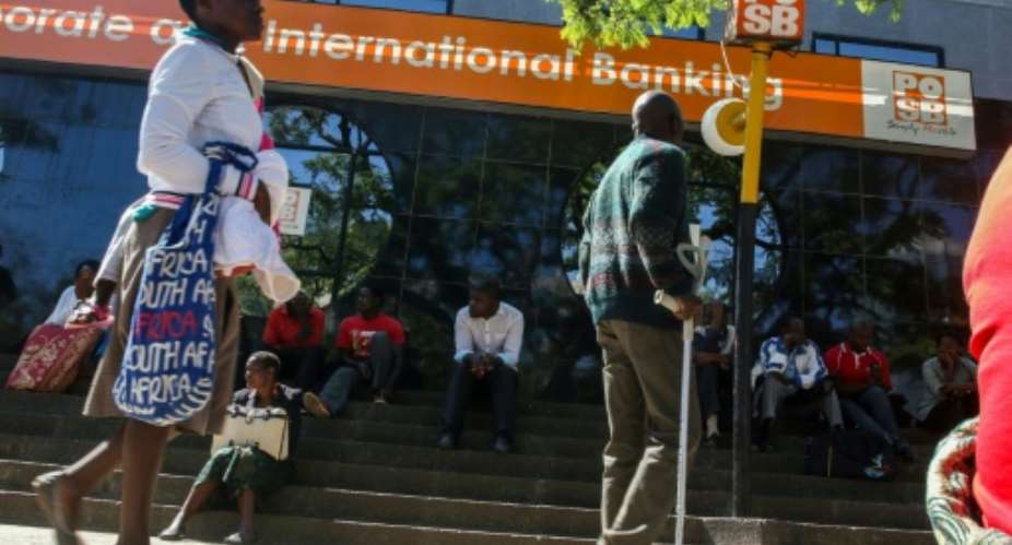 Zimbabweans queue to withdraw cash outside a bank on May 5, 2016 in Harare, Zimbabwe.  By Jekesai Njikizana AFPFile