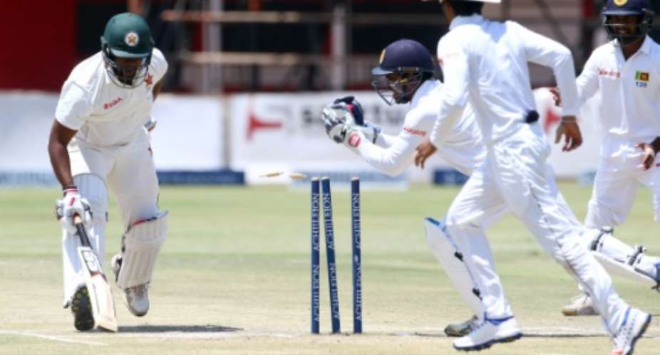 Zimbabwe's batsman Hamilton Masakadza left survives a run out attempt by wicketkeeper Kusal Janith Perera during a Test match in Harare, on November 2, 2016.  By Jekesai Njikizana AFP