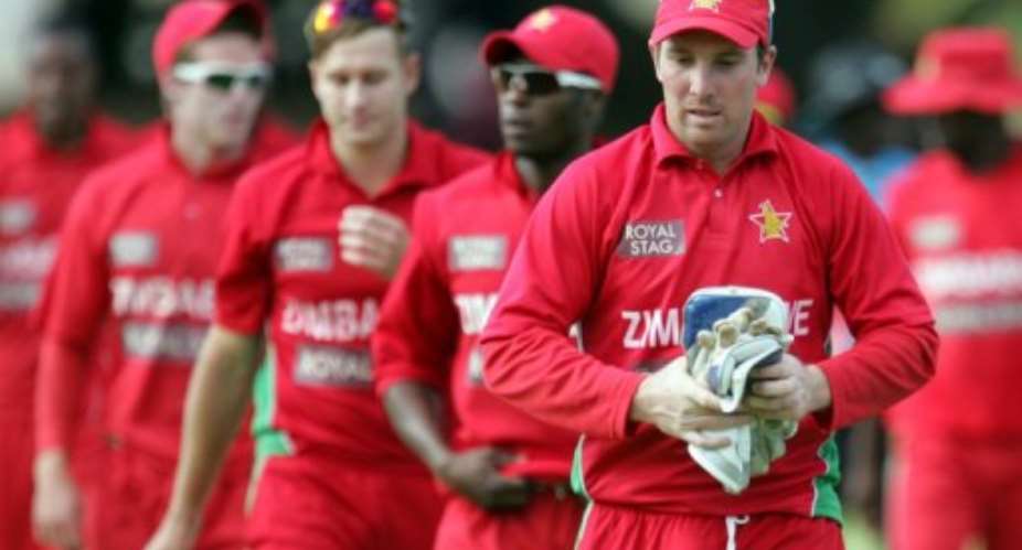 Zimbabwe's Brendan Taylor leaves the field with teammates after loosing to India, in Harare, on August 3, 2013.  By Jekesai Njikizana AFPFile