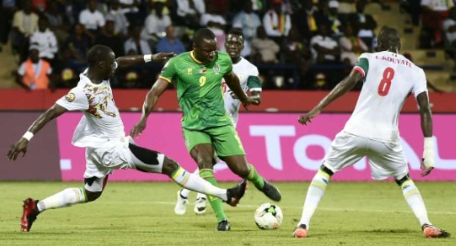 Zimbabwe's forward Nyasha Mushweki C challenges Senegal's defender Lamine Gassama and defender Cheikhou Kouyate R during the 2017 Africa Cup of Nations group B football match January 19, 2017.  By KHALED DESOUKI AFP