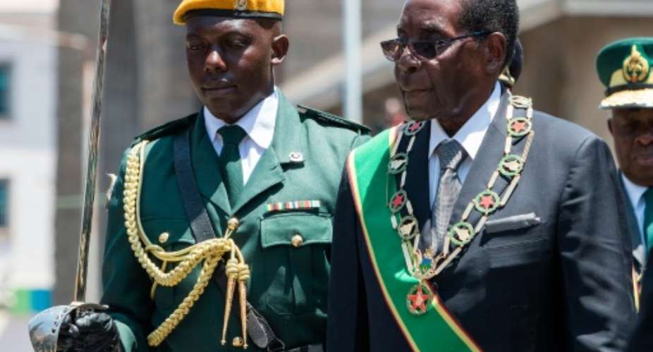 Zimbabwe's President Robert Mugabe R inspects an honor guard during the official opening of the fourth session of the eight Parliament of Zimbabwe in Harare.  By Jekesai Njikizana AFP