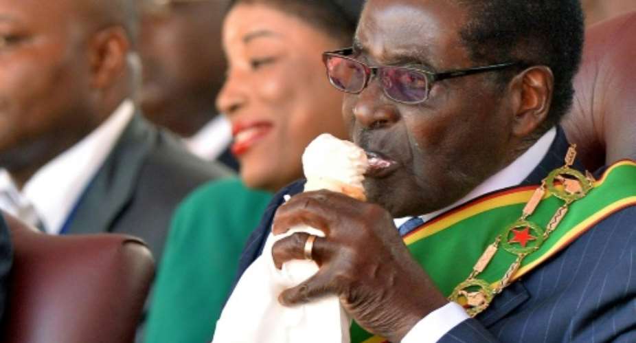 Zimbabwe's Robert Mugabe, seen here eating ice cream at his inauguration after the 2013 elections, owns the large Gushungo dairy.  By Alexander Joe AFPFile