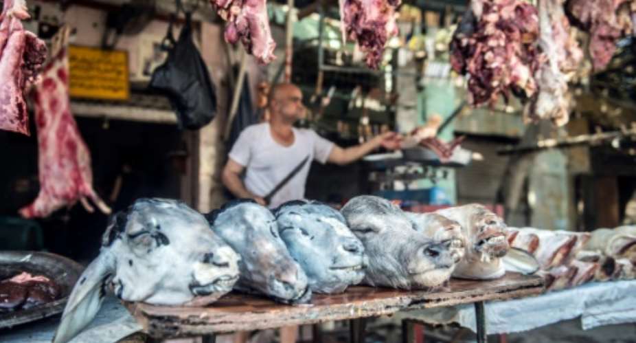 Zinhum Abdelmoneem works at his butchery in Cairo on August 16, 2018, ahead of the annual Muslim Eid al-Adha holiday.  By Khaled DESOUKI AFP