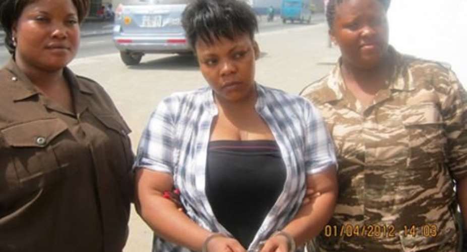 Celestine Donkor middle in handcuffs being escorted by prison officers during the video shoot