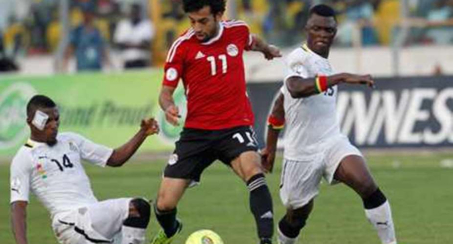 Mohamed Salah C of Egypt fights for the ball with Jerry Akaminki L and Rashid Sumaila of Ghana during their World Cup 2014 African zone qualifying soccer match at the Baba Yara Sports Stadium in Kumasi October 15, 2013.