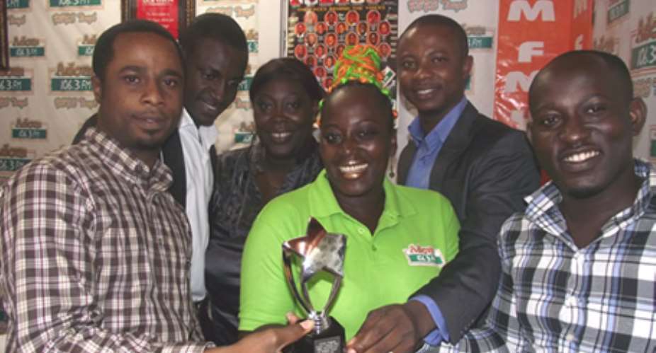 Some Staff of Adom FM admiring the trophy for Best Contribution to African Gospel Music award