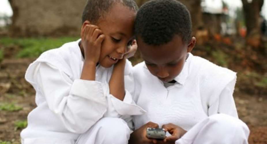 Two boys play with a cellular phone in Debre Zeit, Ethiopia.