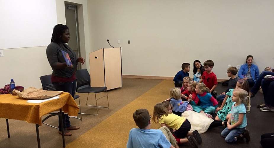 Deborah Ahenkorah narrates Ghanaian childrens story, Abena and the Corn Seed, to a rapt audience of young kids at the Drake Community Library, Grinnell, USA.