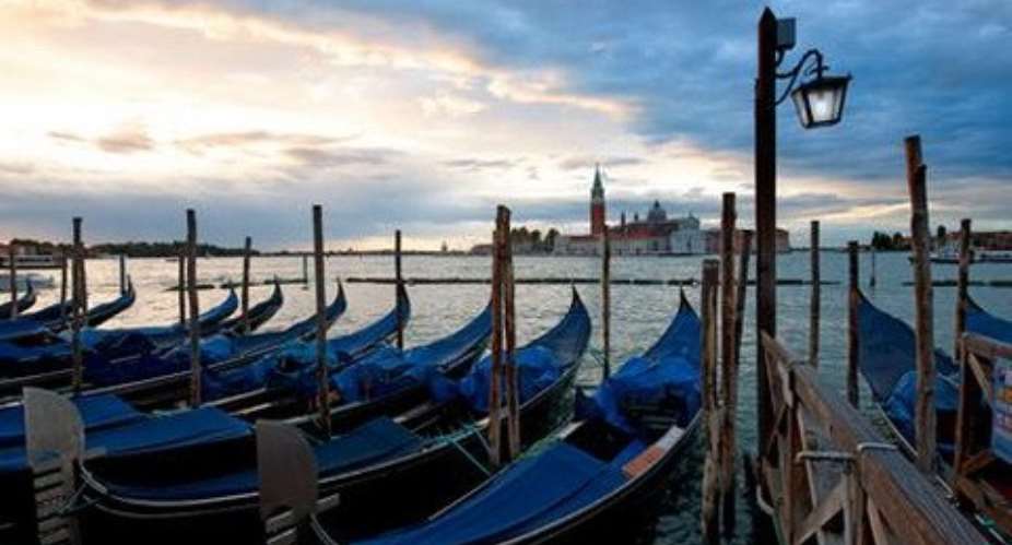 The gondolas bob on the water as the sun sets over Venice. Pete Seaward